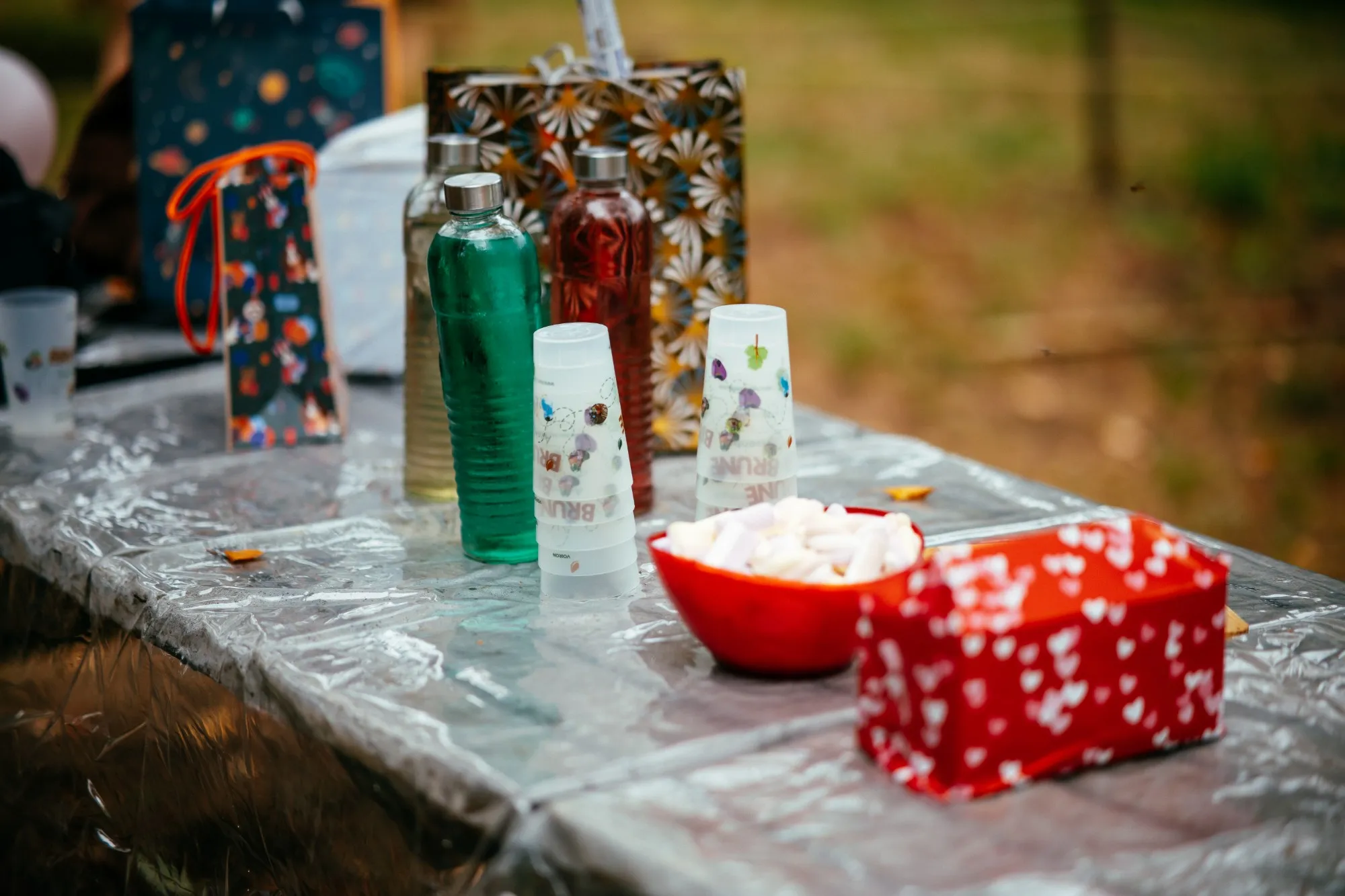 Boissons et écocups Brune Aventure, bonbons et cadeaux sur la table d'anniversaire