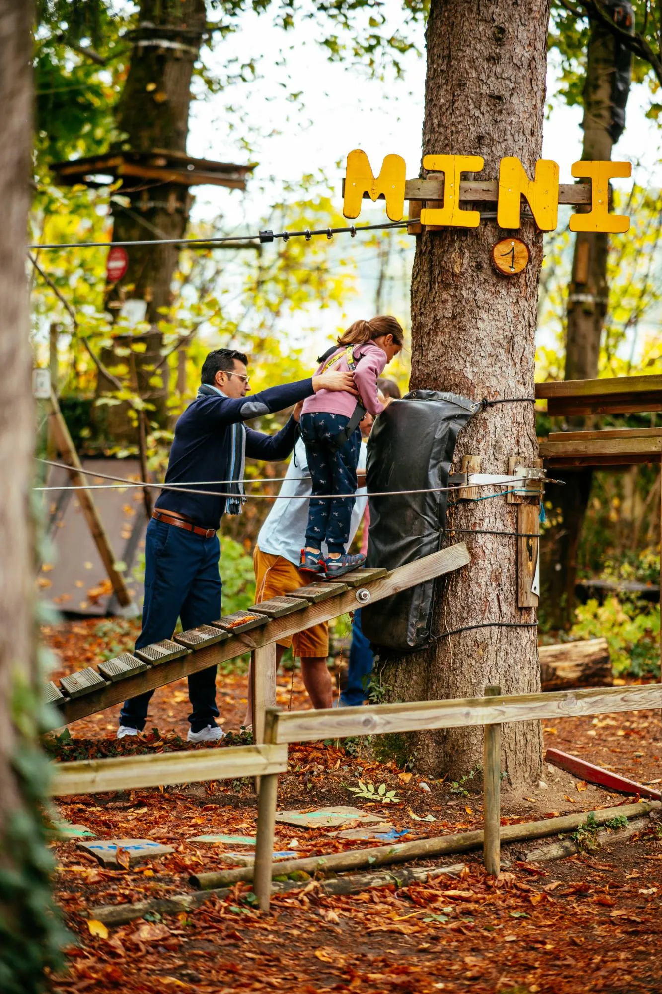 Un papa aide sa fille à monter sur le parcours Mini